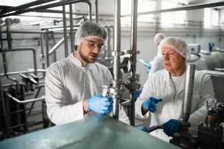 Twee mannen in een zuivelfabriek